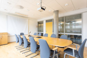 Sandslimarka 251. Møterom med plass til 12 personer, blågrå stoler og ovalt møtebord