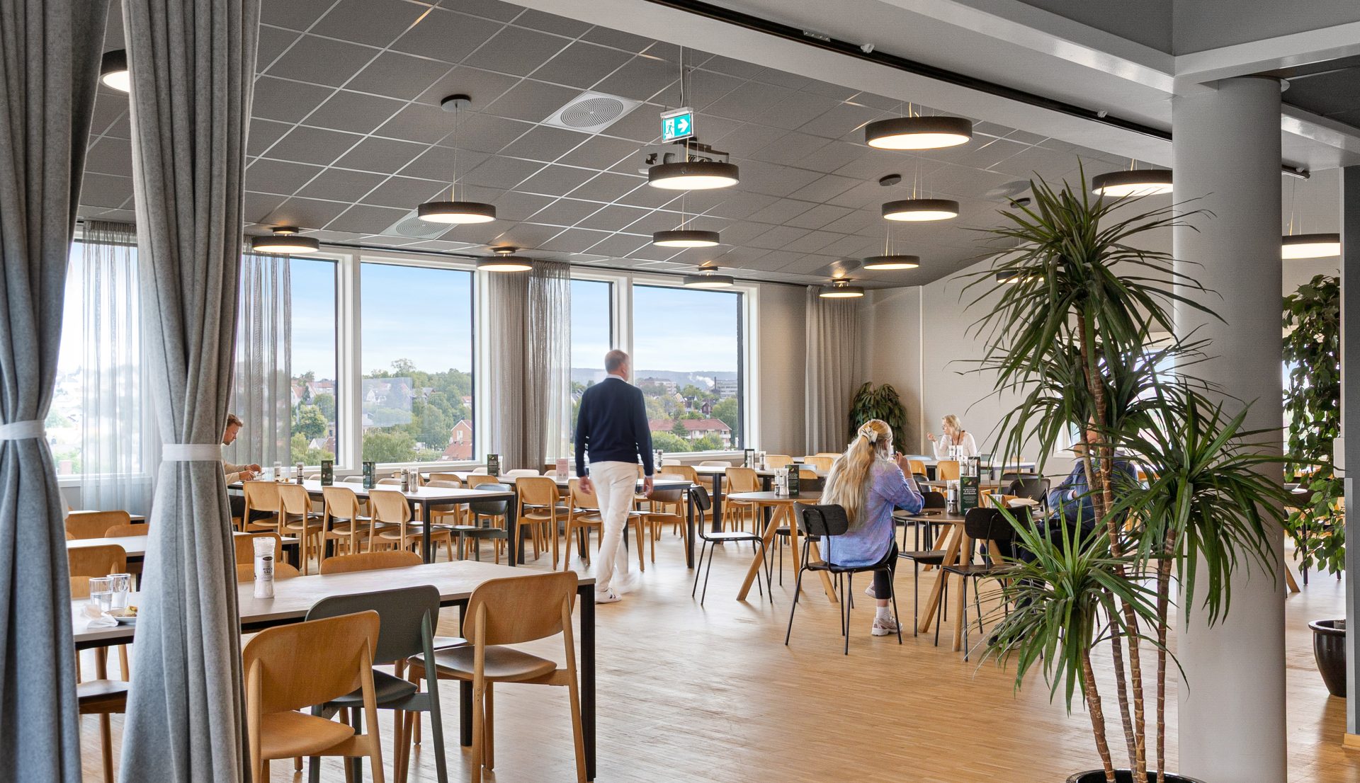 Lys og luftig personalrestaurant med prosjektor og lerret